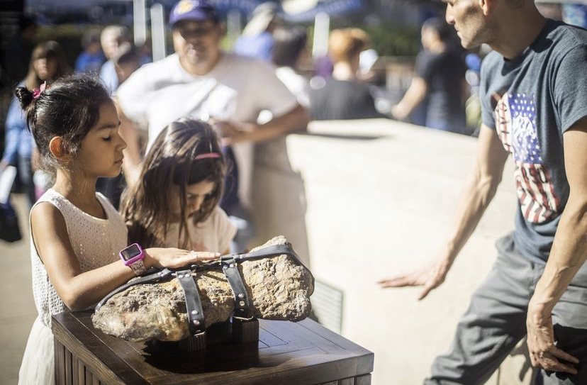 Two girls touching the Inner Freedom meteorite at UCLA Exploring Your Universe 2019