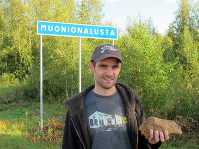 Anton Artemev with a meteorite at the Muonionalusta sign, Sweden
